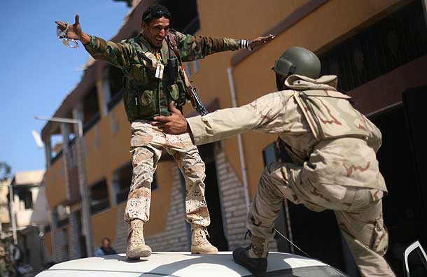 Revolutionary fighters celebrate the capture of Sirte (Pic: AP)