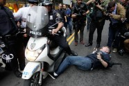 A New York City police officer runs over a National Lawyers Guild observer as Occupy Wall Street demonstrators march through the streets near Wall Street, Friday, Oct. 14, 2011, in New York.