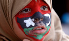 A young anti-Gaddafi protester with the old Libyan flag painted on her face.