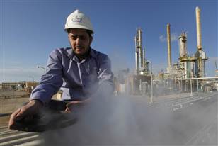 Image: A Libyan oil worker, works at a refinery inside the Brega oil complex
