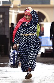 A Tunisian woman crosses the border into Tunisia after fleeing unrest in Libya. Thousands of Tunisians are fleeing Libya after a bloody crackdown on protests against the rule of Moammar Gaddafi.Tunisia has at least 30,000 nationals in Libya, and officials fear they could become targets because of Tunisia's role in inspiring uprisings across the Arab world.