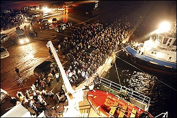 People wait to board a Turkish ferry at the port of Benghazi, Libya, late Tuesday. Governments are scrambling to evacuate their citizens.