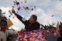 ( Ariana Cubillos / Associated Press ) - Venezuela’s President Hugo Chavez catches a flower thrown by supporters during his caravan from Miraflores presidential palace to the airport in Caracas, Venezuela, Friday Feb. 24, 2012. Chavez bid an emotional goodbye to soldiers and supporters and waved to crowded streets in Caracas on his way to Cuba for urgent surgery to remove a tumor he says is probably malignant.